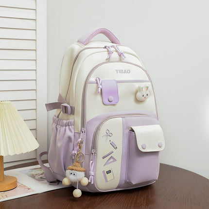 Light purple and white backpack with decorative elements on a wooden surface.