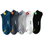 Five pairs of socks in blue, gray, white, and black with visible brand logos on a white background.