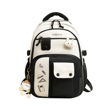 White and black backpack with cartoon character keychain on a white background