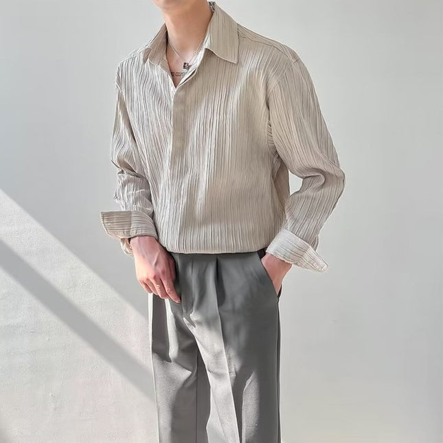 Person wearing a beige striped shirt and gray pants against a light background