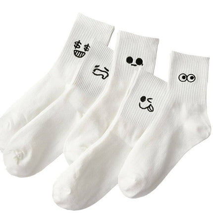 Four white socks with black smiley face designs on a white background