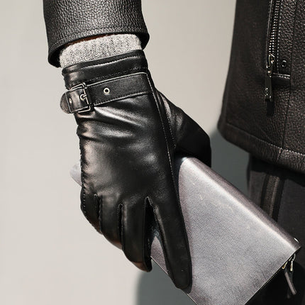 Person wearing black leather gloves holding a silver clutch against a neutral background