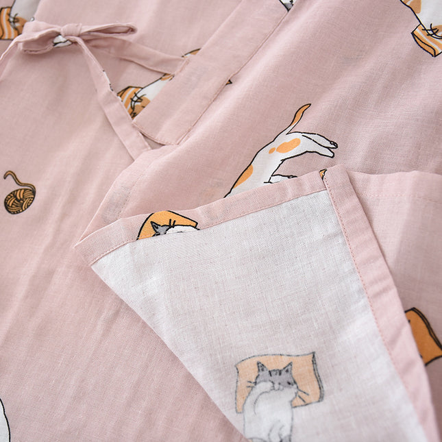 Pink apron with cat illustrations on a matching pink background