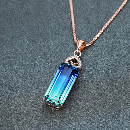 Necklace with a blue gemstone pendant on a gray background