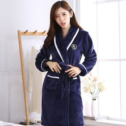 Woman wearing a navy blue robe with white trim in a bright room.