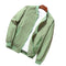 Green jacket on a wooden surface with a white shirt underneath
