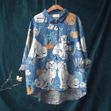 Blue shirt with dog pattern on a hanger against a dark background