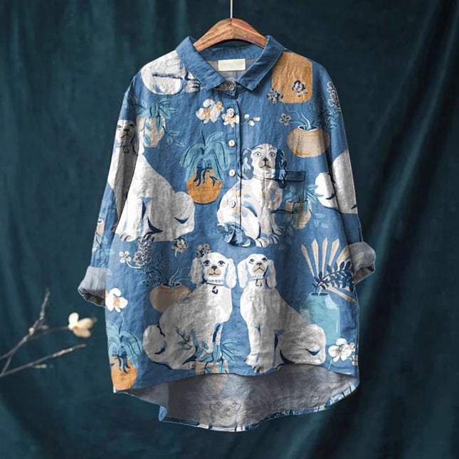 Blue shirt with dog pattern on a hanger against a dark background