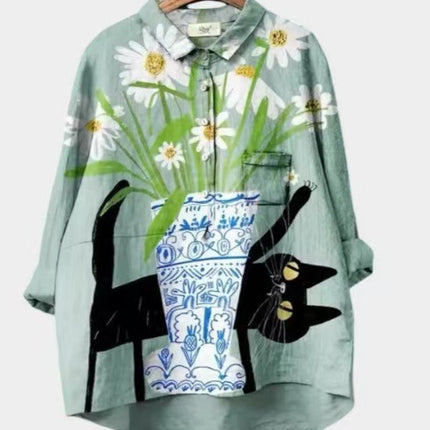 Light green shirt with floral and cat design on a hanger