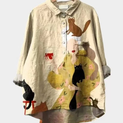 Beige shirt with cat illustrations on a hanger against a white background