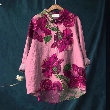 Pink floral shirt on a hanger against a dark background