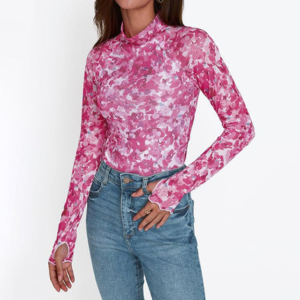 Person wearing a pink camouflage long-sleeve top and blue jeans on a white background