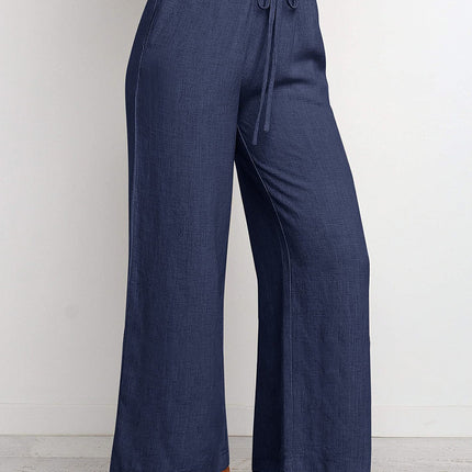 Navy blue wide-leg pants with a tie waist on a white background