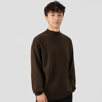 Person wearing a brown sweater on a plain background