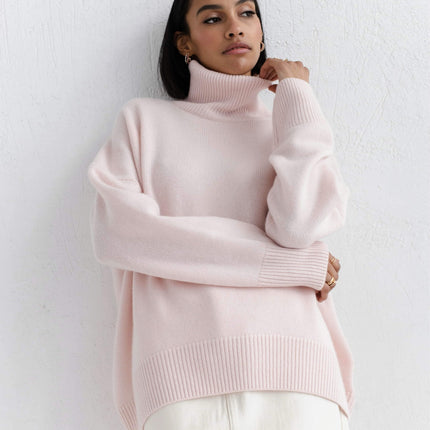 Woman wearing a light pink sweater against a white background