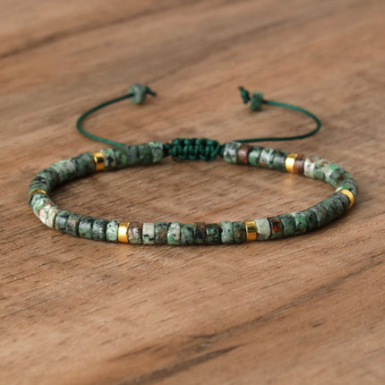 Hand-woven adjustable bracelet featuring natural green stone beads with gold accents on a wooden background.