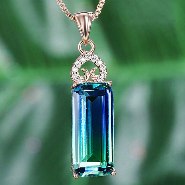 Jewelry pendant with a green gemstone on a blurred green background