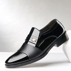 Black dress shoe with a silver buckle on a white background