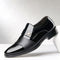 Black dress shoe with a silver buckle on a white background