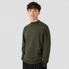 Man wearing a green sweater against a plain background