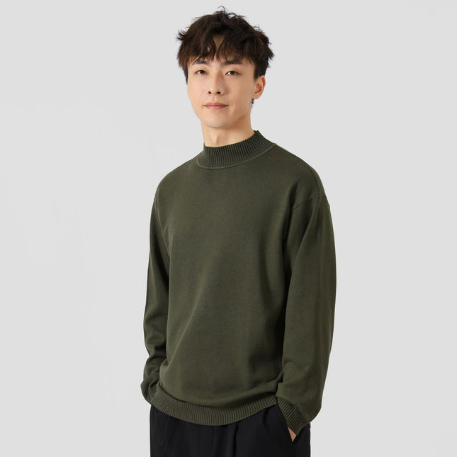 Man wearing a green sweater against a plain background
