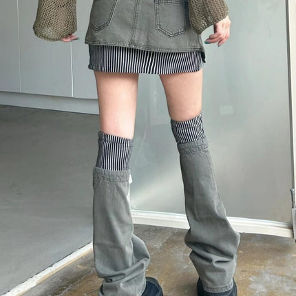 Person wearing a green skirt, striped socks, and gray pants with black shoes in an indoor setting.