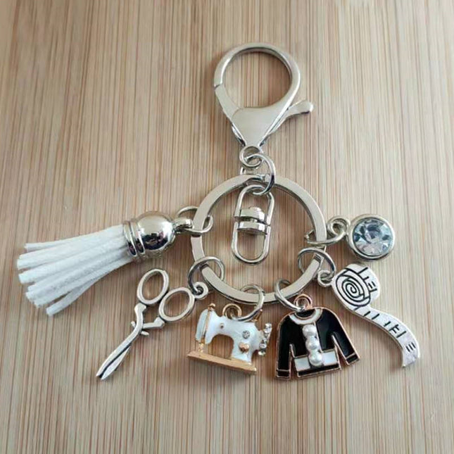 Keychain with sewing-themed charms on a wooden surface
