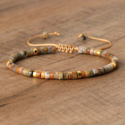 Natural stone spacer bead bracelet with adjustable tie, featuring a woven design in earthy tones and golden accents.