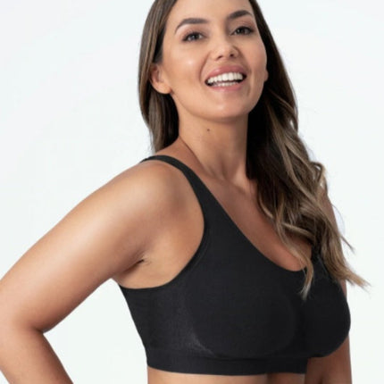 Woman wearing a black sports bra against a plain background