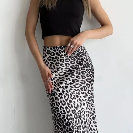 Person wearing a black crop top and leopard print skirt against a light background