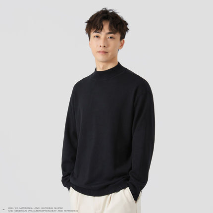 Man wearing a black sweater against a plain background