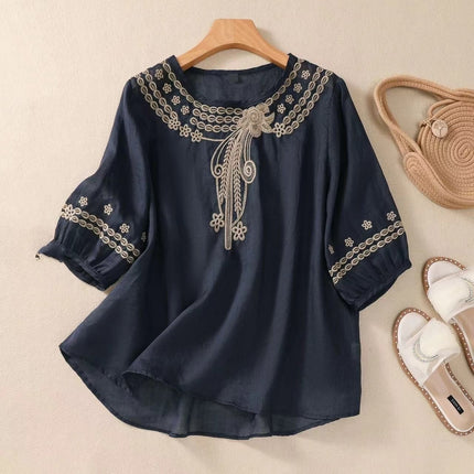 Navy blue blouse with white embroidery on a beige background
