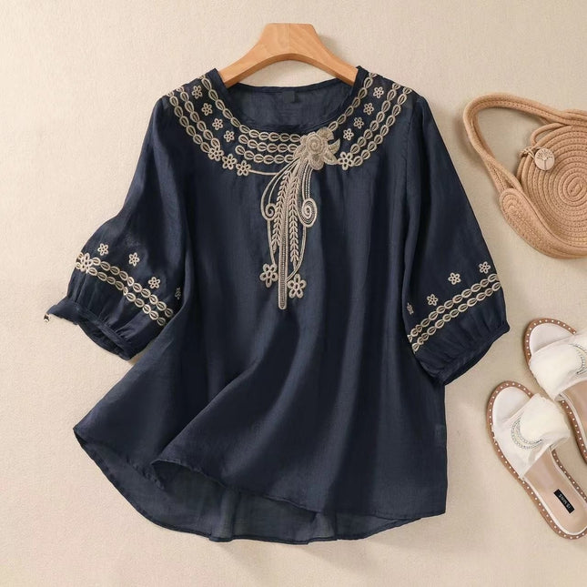 Navy blue blouse with white embroidery on a beige background