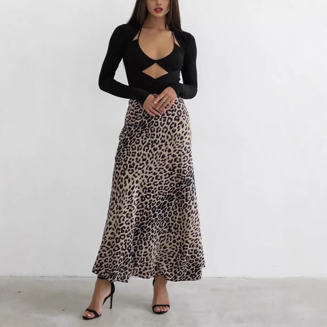 Woman wearing a black long-sleeve top and leopard print skirt on a white background