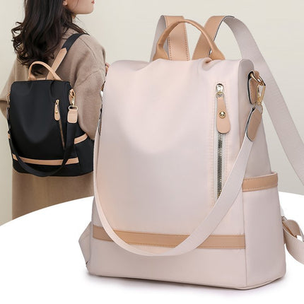 Two backpacks, one black and one beige with tan accents, on a white surface.