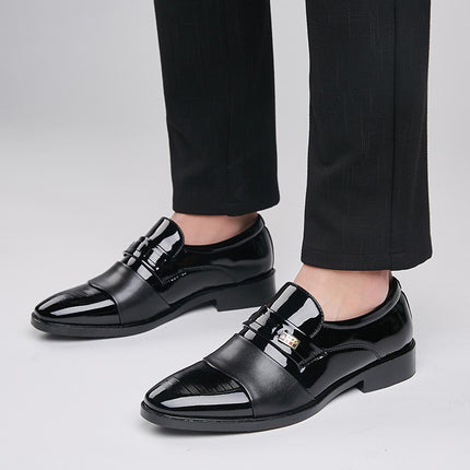 Black dress shoes worn with black pants on a light gray background