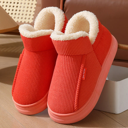 Red slip-on shoes with white fur lining on a wooden floor.
