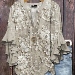 Lace top with ruffled sleeves and a necklace on a wooden background