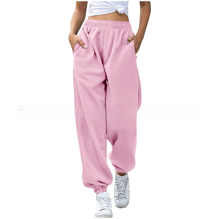 Pink sweatpants worn by a person on a white background