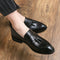 Black loafers with tassels worn on a wooden floor