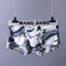 Men's underwear with bird and leaf pattern hanging on a gray background with 'WANG JIANG' branding.
