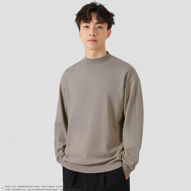Man wearing a beige sweater against a plain background