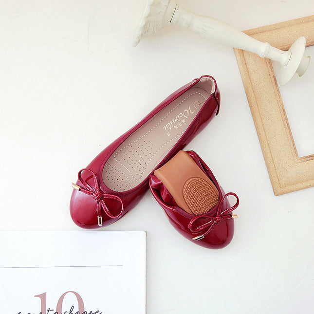 Foldable burgundy ballet shoes with flat heel and bow detail, soft bottom for comfort and style.