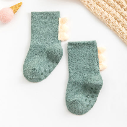 Pair of green socks with textured sole on a white background