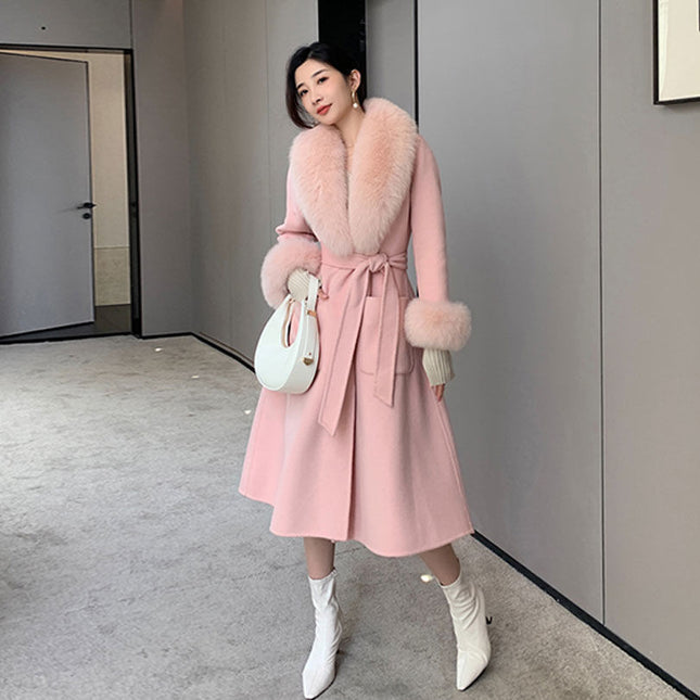 Woman wearing a pink coat with fur trim in an indoor setting