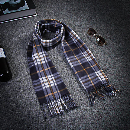 Plaid scarf on a dark surface with sunglasses and a book in the background